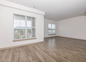 Thumbnail 16 of 30 - A room with wooden flooring and a window with blinds.