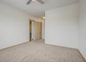 Thumbnail 26 of 30 - A room with a carpeted floor and a ceiling fan.