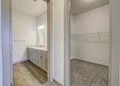 Thumbnail 18 of 30 - A walk in closet with a mirror and shelves.