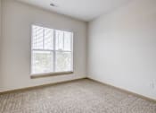Thumbnail 9 of 30 - A room with a window and carpeted floor.
