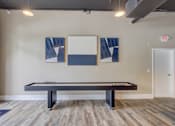 Thumbnail 19 of 30 - A pool table in a room with two framed pictures on the wall.