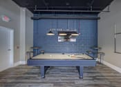 Thumbnail 17 of 30 - A pool table is in the middle of a room with a blue wall.