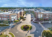 Thumbnail 8 of 30 - A roundabout in a residential area with apartment buildings on either side.