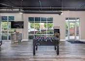 Thumbnail 6 of 30 - A black pool table in a room with a television and a window.