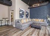Thumbnail 3 of 30 - A grey couch with yellow pillows sits in a room with wooden floors.