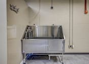 Thumbnail 25 of 30 - A large metal container sits on a metal frame in a room with white walls.