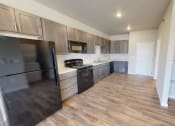 Thumbnail 26 of 54 - a kitchen with wood flooring and stainless steel appliances and