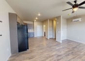 Thumbnail 24 of 54 - an empty living room with a kitchen and a ceiling fan