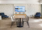 Thumbnail 13 of 36 - A conference room with a large screen and chairs.