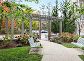 Thumbnail 22 of 36 - A park with benches and a walkway.