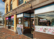 Thumbnail 35 of 36 - A pizza shop named Pasha is located on a brick street.