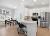 Thumbnail 2 of 43 - a large white kitchen with a large island and stainless steel appliances