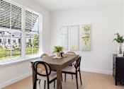 Thumbnail 9 of 43 - a dining room with a wooden table and chairs and a large window