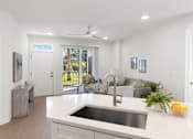 Thumbnail 3 of 43 - an open kitchen and living room with white walls and white counter tops and a sink