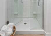 Thumbnail 10 of 43 - a shower with a glass door in a white bathroom