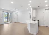 Thumbnail 19 of 43 - an empty living room with a kitchen and a balcony