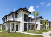 Thumbnail 40 of 43 - a group of white homes with palm trees in front of them