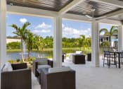 Thumbnail 31 of 43 - a covered patio with a view of a body of water and palm trees