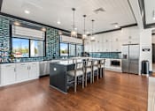 Thumbnail 51 of 52 - A modern kitchen with a large island and wooden floors at Ovation at Town Madison, Madison, Alabama
