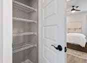 Thumbnail 31 of 52 - A white door is open to a room with a ceiling fan and a bed at Ovation at Town Madison, Madison