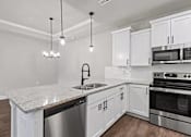 Thumbnail 23 of 34 - A modern kitchen with white cabinets and stainless steel appliances. at The Villas at Nature Walk, Huntsville, AL, 35824