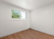 Thumbnail 14 of 19 - the living room of an empty house with a window and wooden floors