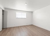 Thumbnail 5 of 19 - the living room of an apartment with white walls and wood floors