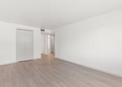 Thumbnail 4 of 19 - an empty living room with white walls and wood flooring