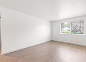Thumbnail 8 of 19 - the living room of an apartment with white walls and wood floors