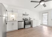 Thumbnail 1 of 19 - an empty kitchen with white appliances and a ceiling fan