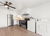Thumbnail 13 of 19 - a white kitchen with stainless steel appliances and a ceiling fan