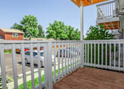Thumbnail 10 of 11 - A white picket fence separates a house from a parking lot.
