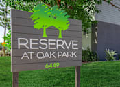 Thumbnail 11 of 11 - A sign for Reserve at Oak Park with a green tree graphic.