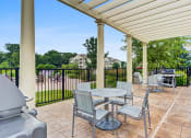 Thumbnail 4 of 15 - Vernon Hills Luxury Apartments - The Oaks of Vernon Hills - Covered Grill Area with BBQs and Tables with Chairs.
