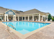 Thumbnail 1 of 15 - Luxury Apartments In Vernon Hills, IL - The Oaks of Vernon Hills - Resort-Style Swimming Pool With Lounge Chairs, And Resident Clubhouse In The Background