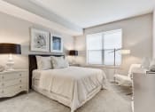 Thumbnail 12 of 15 - Apartments In Vernon Hills, IL For Rent - The Oaks of Vernon Hills - Spacious Bedroom With High Ceilings, Carpet Flooring, Bed, Nightstands With Lamps, Dresser, Floor Lamp, And Large Window With Blinds