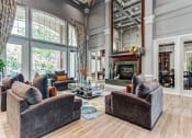 Thumbnail 6 of 20 - Townhomes Aurora, IL - Kirkland Crossing - Clubhouse with a Fireplace, Floor-to-Ceiling Windows, and Seating Area