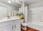Thumbnail 16 of 20 - Townhomes in Aurora, IL - Kirkland Crossing - Bathroom with a Bathtub, Wood-Style Floors, and Quartz Sink