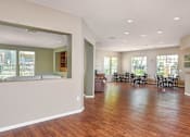 Thumbnail 25 of 30 - A large open living room with a dining area and kitchen in the background.