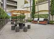 Thumbnail 3 of 30 - A patio with a table, chairs, and umbrella.