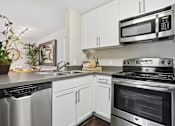 Thumbnail 14 of 30 - A modern kitchen with stainless steel appliances and white cabinets.