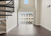 Thumbnail 19 of 30 - A room with a wooden floor and a balcony with a railing.