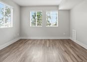 Thumbnail 15 of 30 - A room with wooden flooring and two windows with blinds.