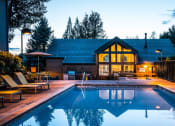 Thumbnail 23 of 31 - 1-Bedroom Apartments In Mountain Park, OR - MiLO - Swimming Pool With Lounge Chairs, Umbrella Table And Chairs, Hot Tub, BBQ Area, And Clubhouse In The Background.