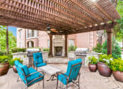 Thumbnail 16 of 20 - Luxury Apartments in North Dallas TX- Outdoor Patio With Fireplace, Two Grills, and Comfortable Blue Outdoor Chairs
