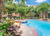 Thumbnail 20 of 20 - Apartments in North Dallas for Rent-Sparkling Swimming Pool With Volleyball Net Surrounded by Lounge Chairs and Seating
