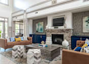 Thumbnail 6 of 14 - A living room with a fireplace and a television on the wall.