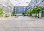 Thumbnail 18 of 18 - Green Lake, Seattle, WA, Apartments For Rent - Circa Green Lake - Courtyard With Picnic Tables And Chairs, Cafe Lights, Plants, Trees, And Surrounding Apartment Buildings.