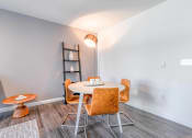 Thumbnail 3 of 18 - a dining area with a round table and orange chairs