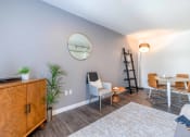 Thumbnail 4 of 18 - a living room with grey walls and a round mirror on the wall